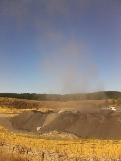 Water truck stirring up a plume of dust.