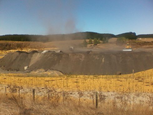Rising plume of dust above coal ash pile.